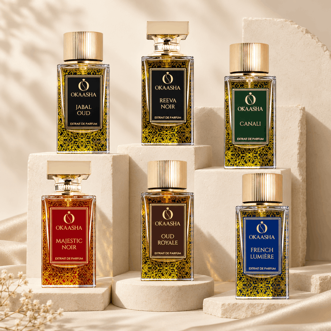 Six Okasha perfume bottles arranged on white pedestals against a warm beige backdrop. They are representing the middle eastern them of sandstones in background.